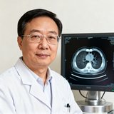 某三甲医院影像中心主任，佩戴眼镜，身后是医疗影像设备显示器。